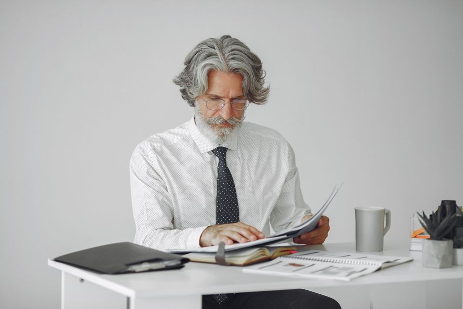 A worker in their 50s reviewing a retirement plan document and smiling