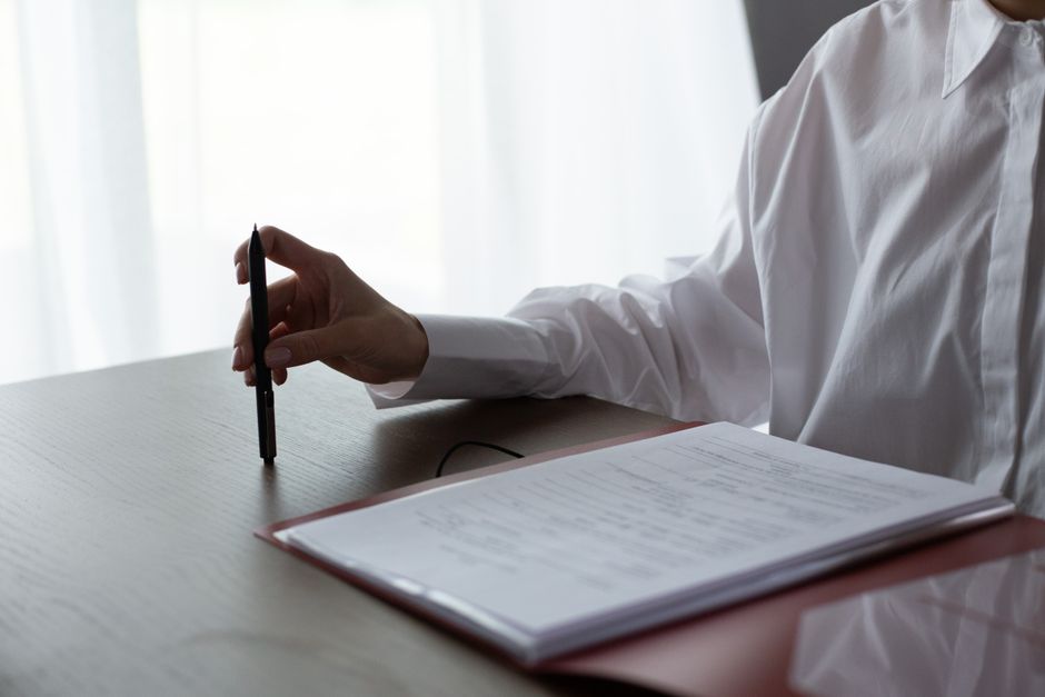 A person reviewing an application form at a desk with several documents spread out, showing focused attention to detail - free immigration lawyer help mcallen tx A person reviewing an application form at a desk with several documents spread out, showing focused attention to detail - free immigration lawyer help mcallen tx