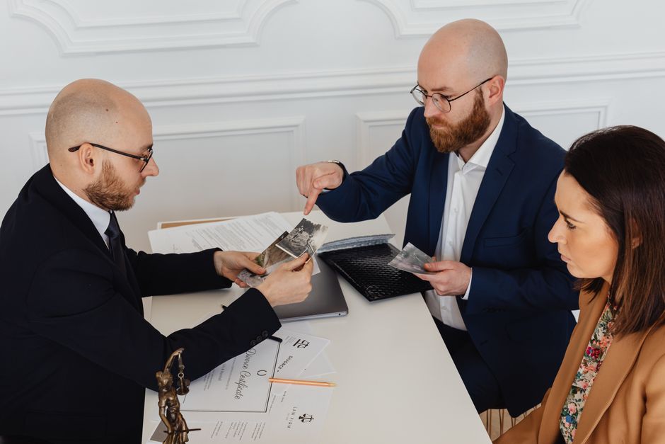 A lawyer consulting with a client over documents in an office setting, pointing to a document with a pen - visitor visa lawyer A lawyer consulting with a client over documents in an office setting, pointing to a document with a pen - visitor visa lawyer